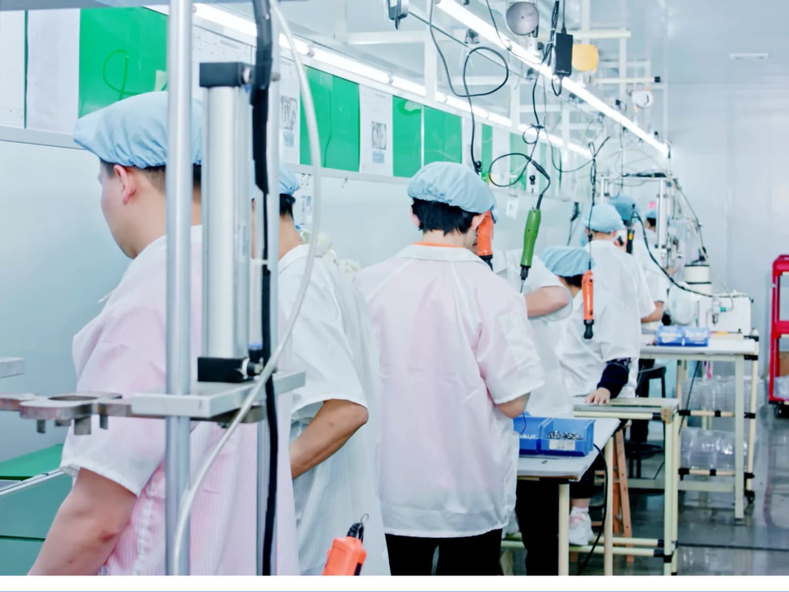 Technicians in cleanroom suits working on a dust-free assembly line